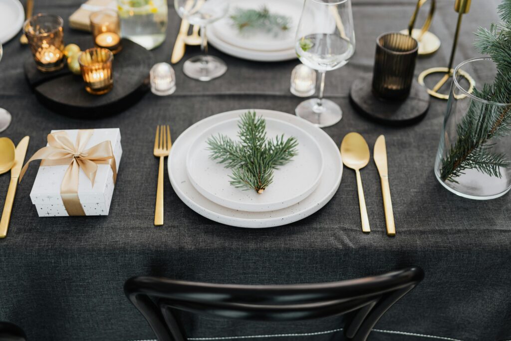 Mesa para uma ceia de natal minimalista com pratos bem servidos e decoração clean.