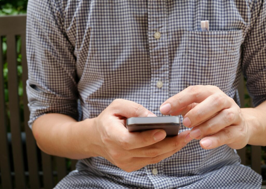 Pessoa usando o celular para quebrar o hábito de comprar online e evitar compras por impulso.
